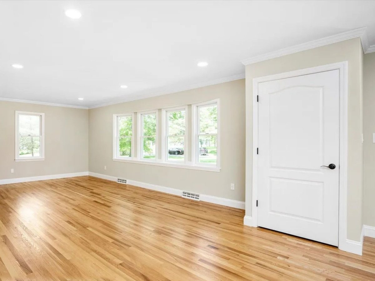 empty sunlit room with hardwood floors and multiple windows in a houghton contracting custom home project in trenton new jersey