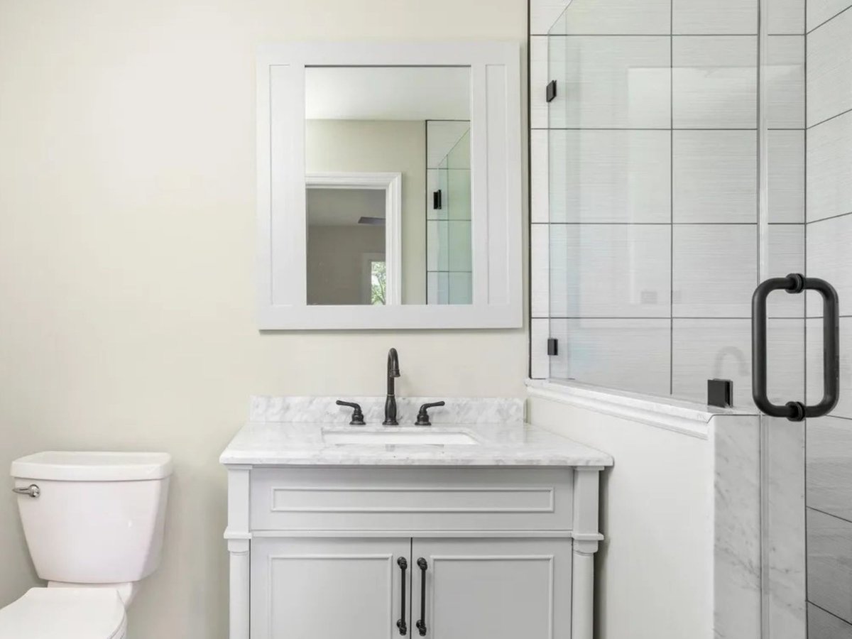 powder room with marble vanity and glass shower door in a houghton contracting custom home project in trenton new jersey