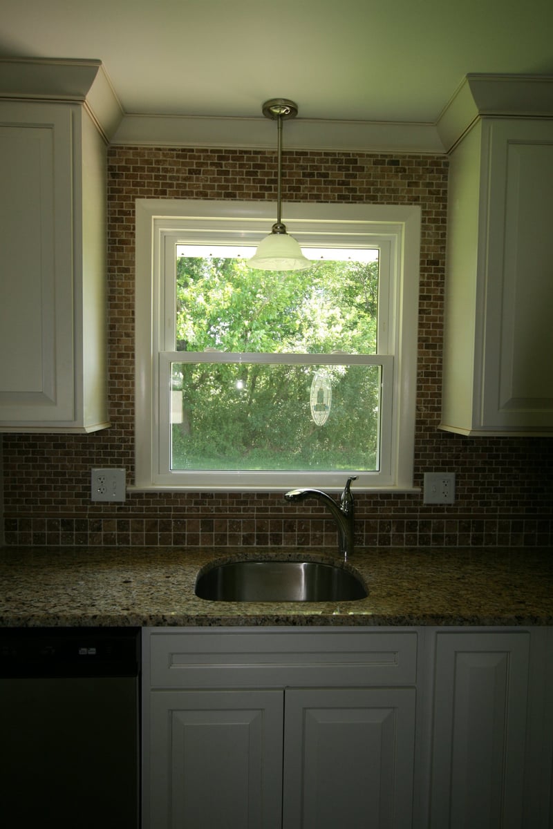 close view of kitchen sink and glass pendant light over granite counter houghton contracting custom home project in ewing new jersey