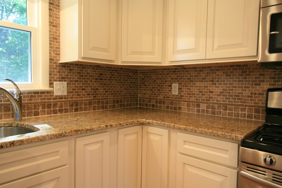 granite countertops and mosaic tile backsplash with white cabinets houghton contracting custom home project in ewing new jersey
