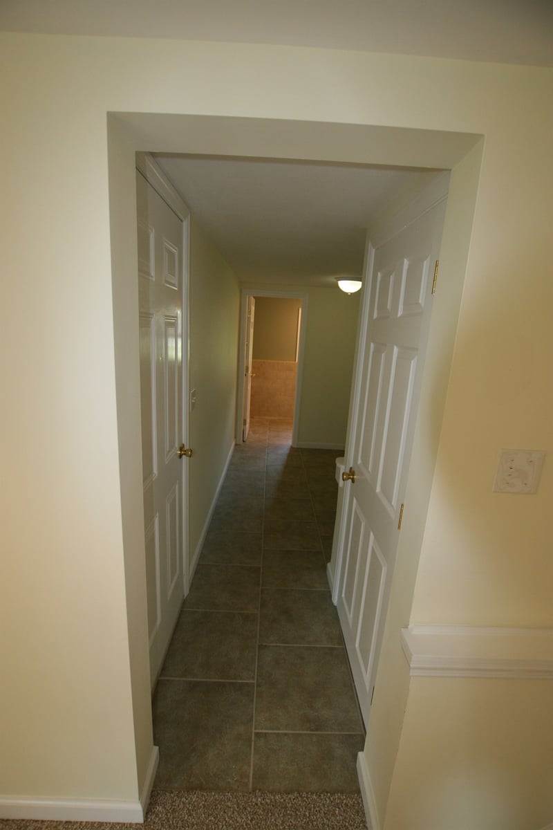hallway with tile flooring and paneled doors leading to bathroom houghton contracting custom home project in ewing new jersey