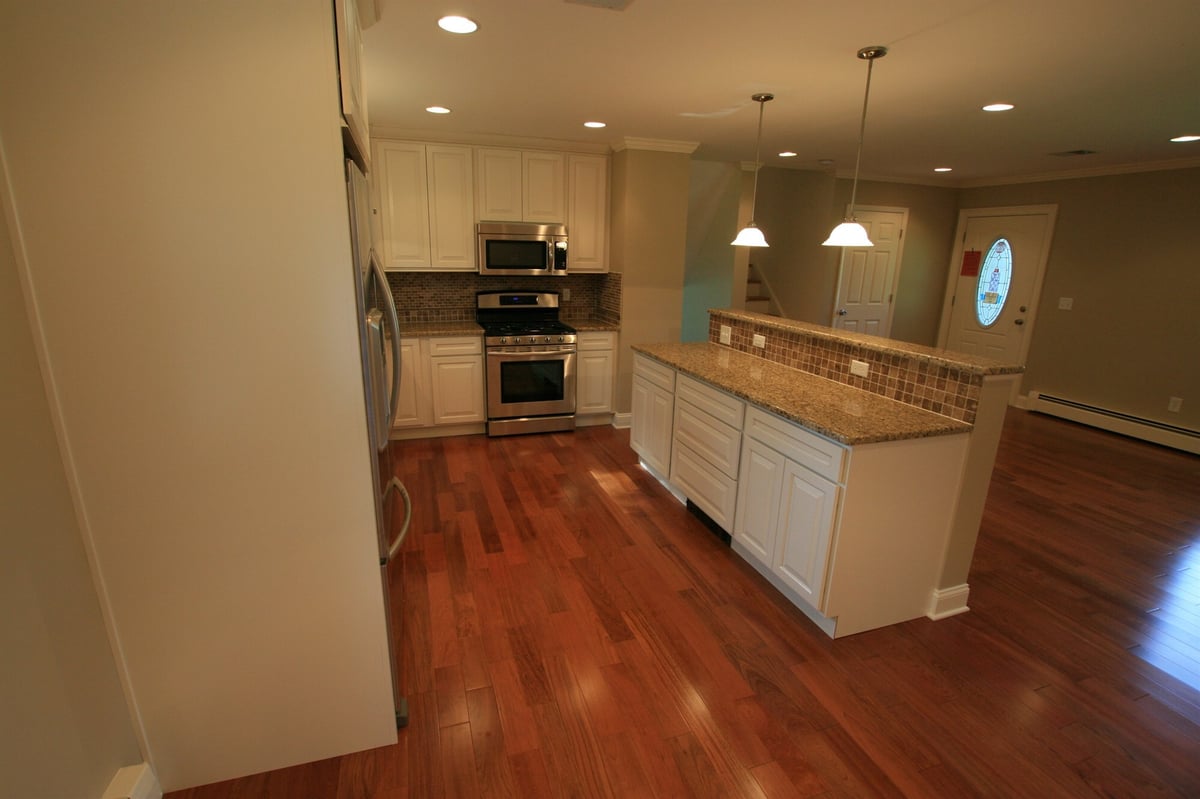 kitchen island and breakfast bar overlooking front entry with hardwood floors custom home project by houghton contracting in ewing new jersey