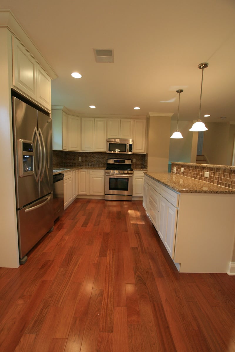 kitchen with stainless steel appliances and granite island under pendant lights houghton contracting custom home project in ewing new jersey