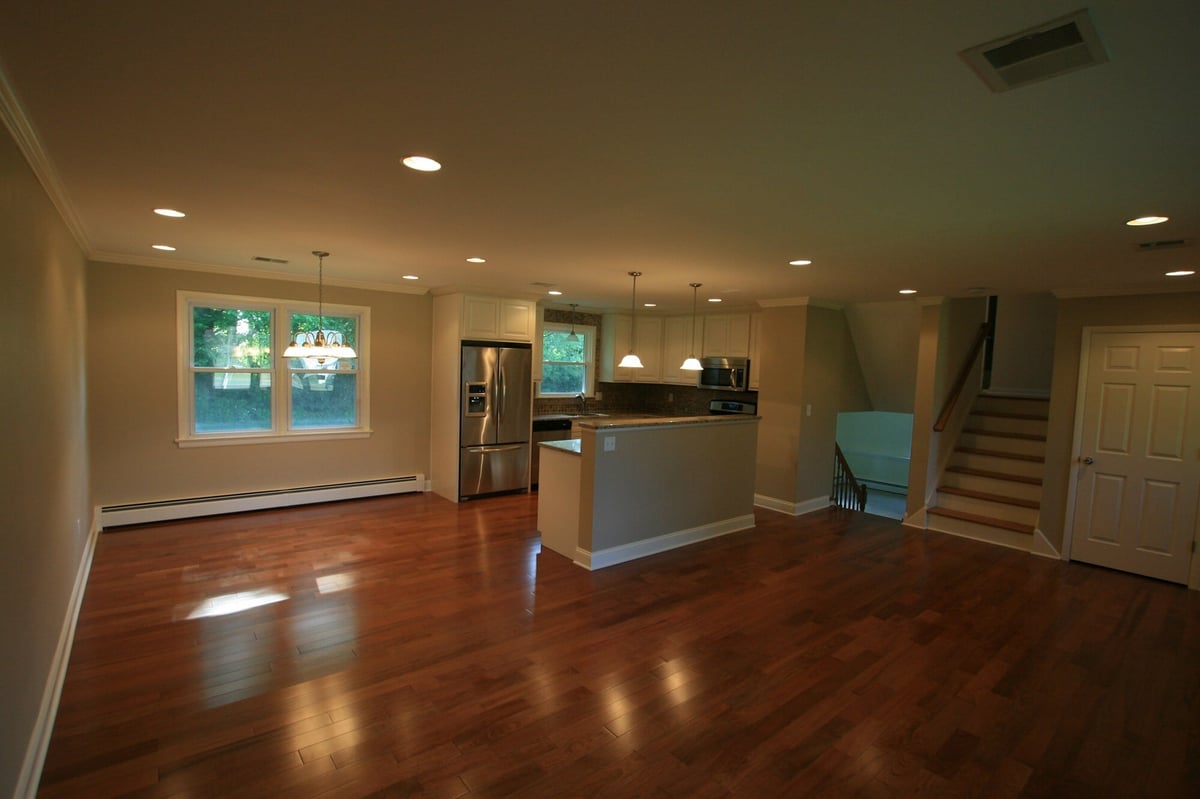 open concept living and kitchen area with hardwood floors and staircase custom home project by houghton contracting in ewing new jersey