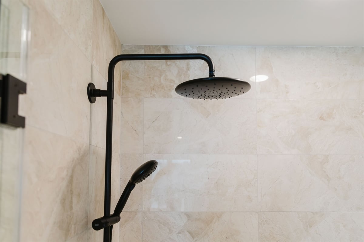 matte black shower fixtures mounted on marble tile wall home addition project by houghton contracting in lawrenceville new jersey-optimized