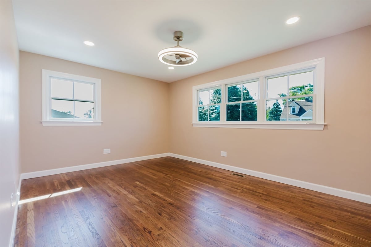 primary bedroom with triple window and hardwood floors home addition project by houghton contracting in lawrenceville new jersey-optimized