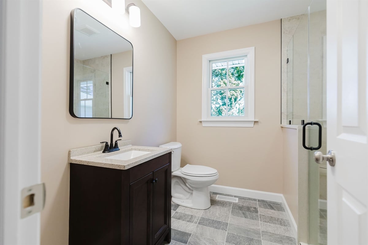 second bathroom with dark vanity and glass shower home addition project by houghton contracting in lawrenceville new jersey-optimized