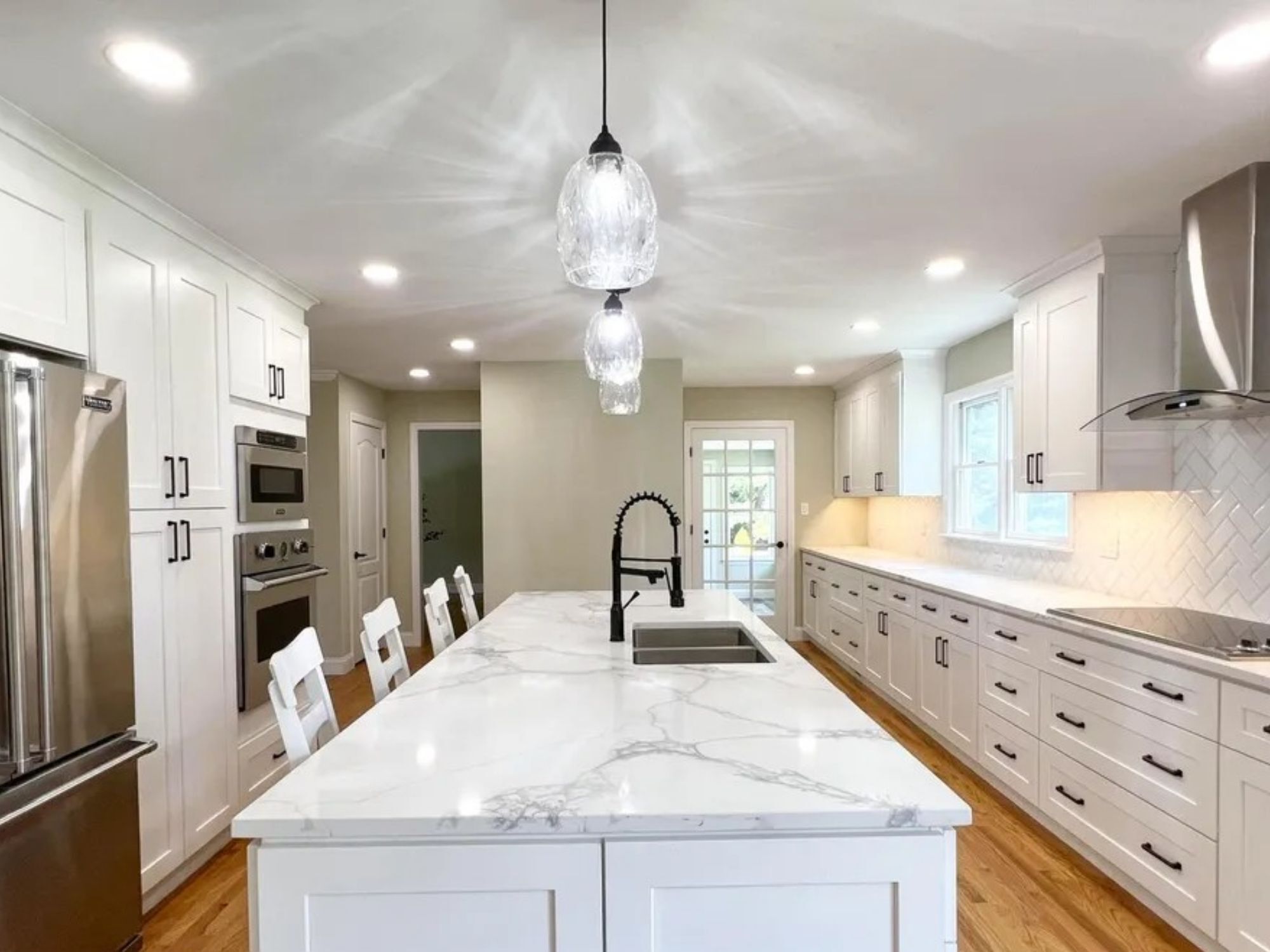 kitchen island with pendant lighting and farmhouse faucet in a houghton contracting custom home project in trenton new jersey