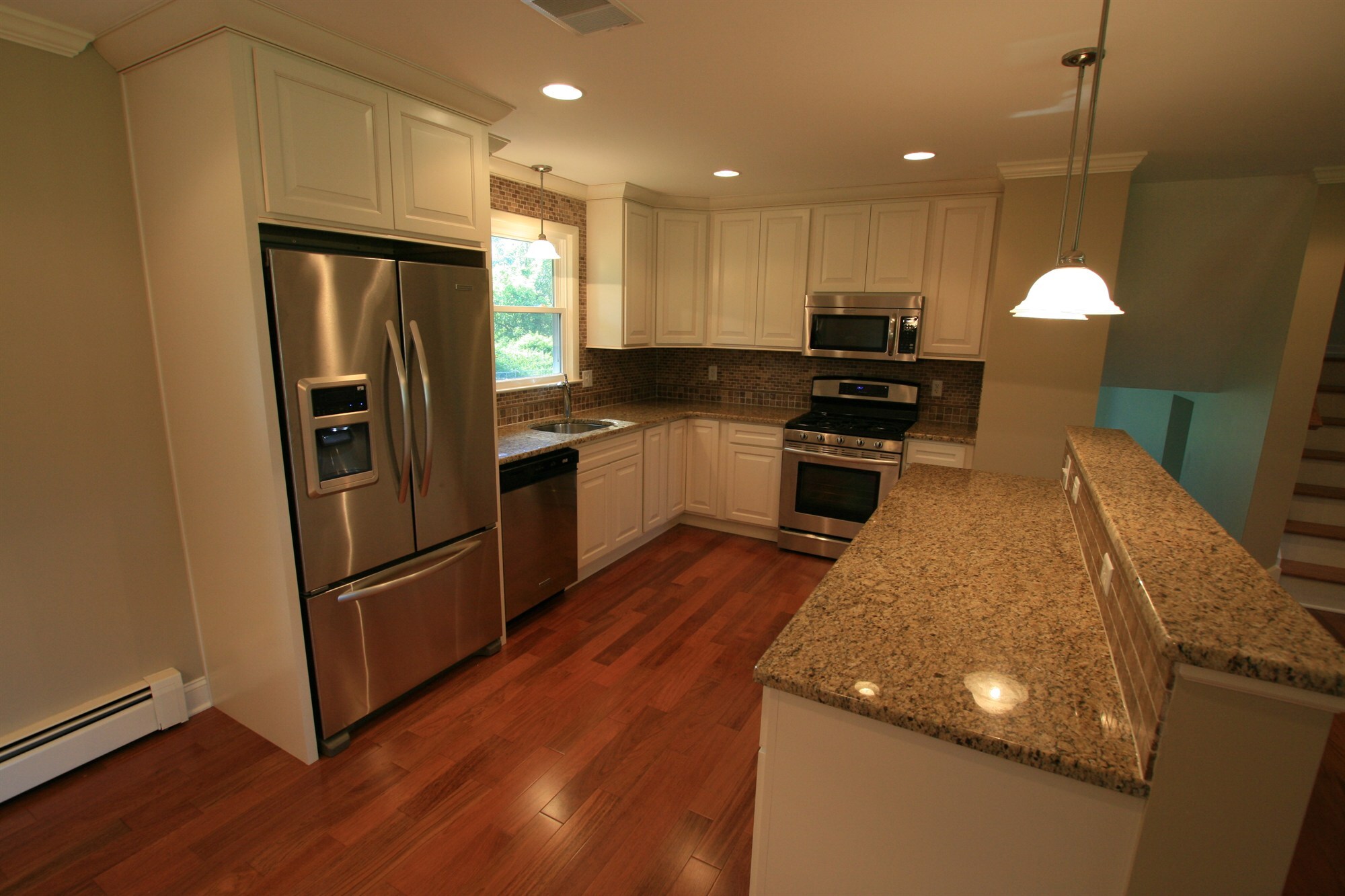 l shaped kitchen with french door refrigerator and raised granite bar houghton contracting custom home project in ewing new jersey