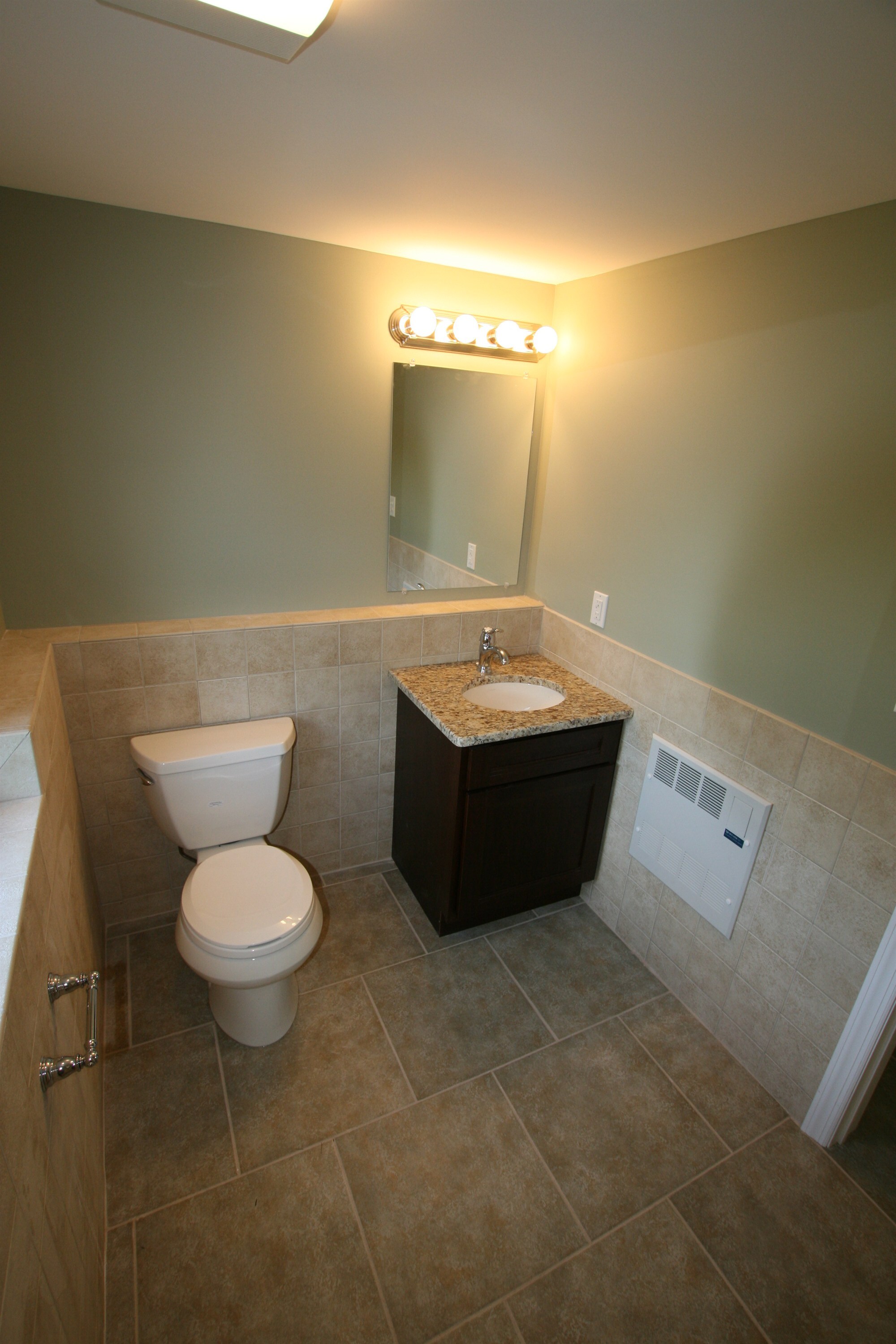 powder room with dark vanity granite top and tile wainscoting custom home project by houghton contracting in ewing new jersey